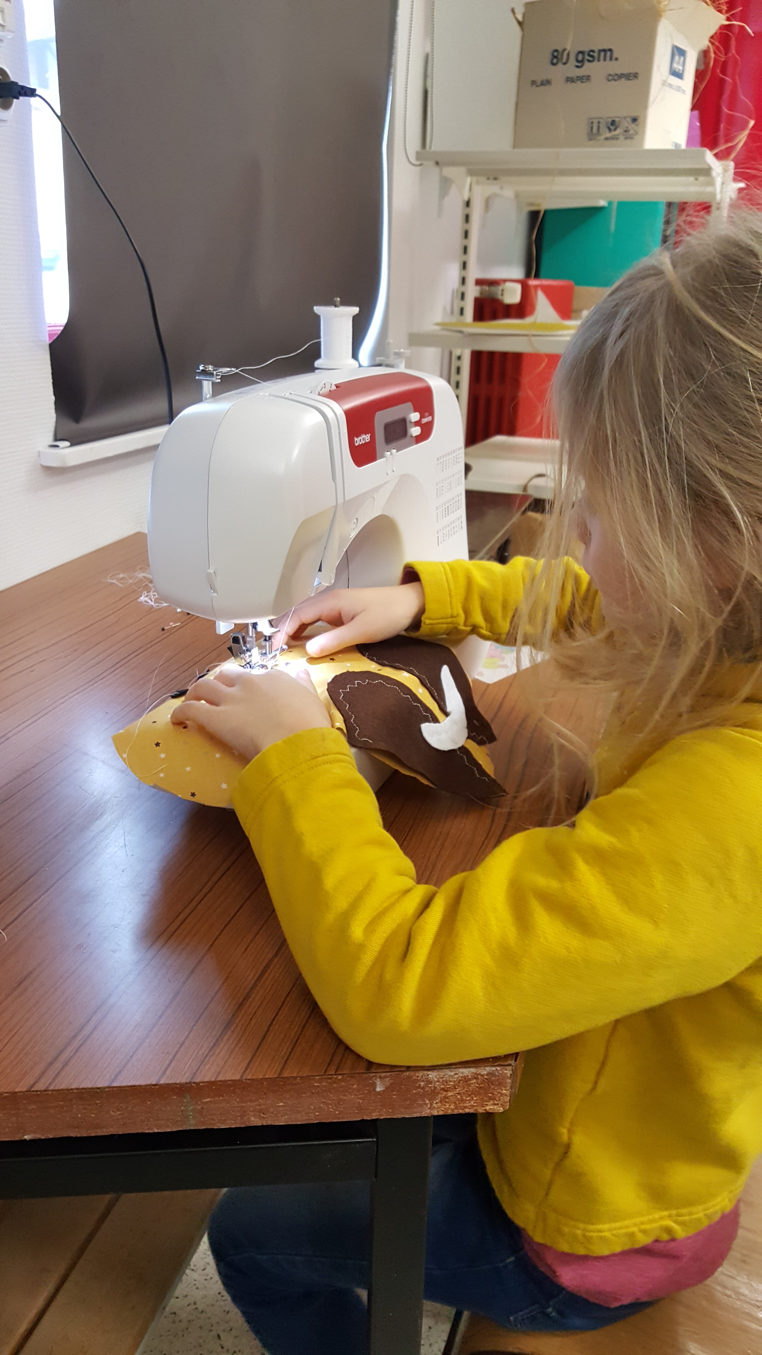 Un enfant qui coud à la machine à coudre