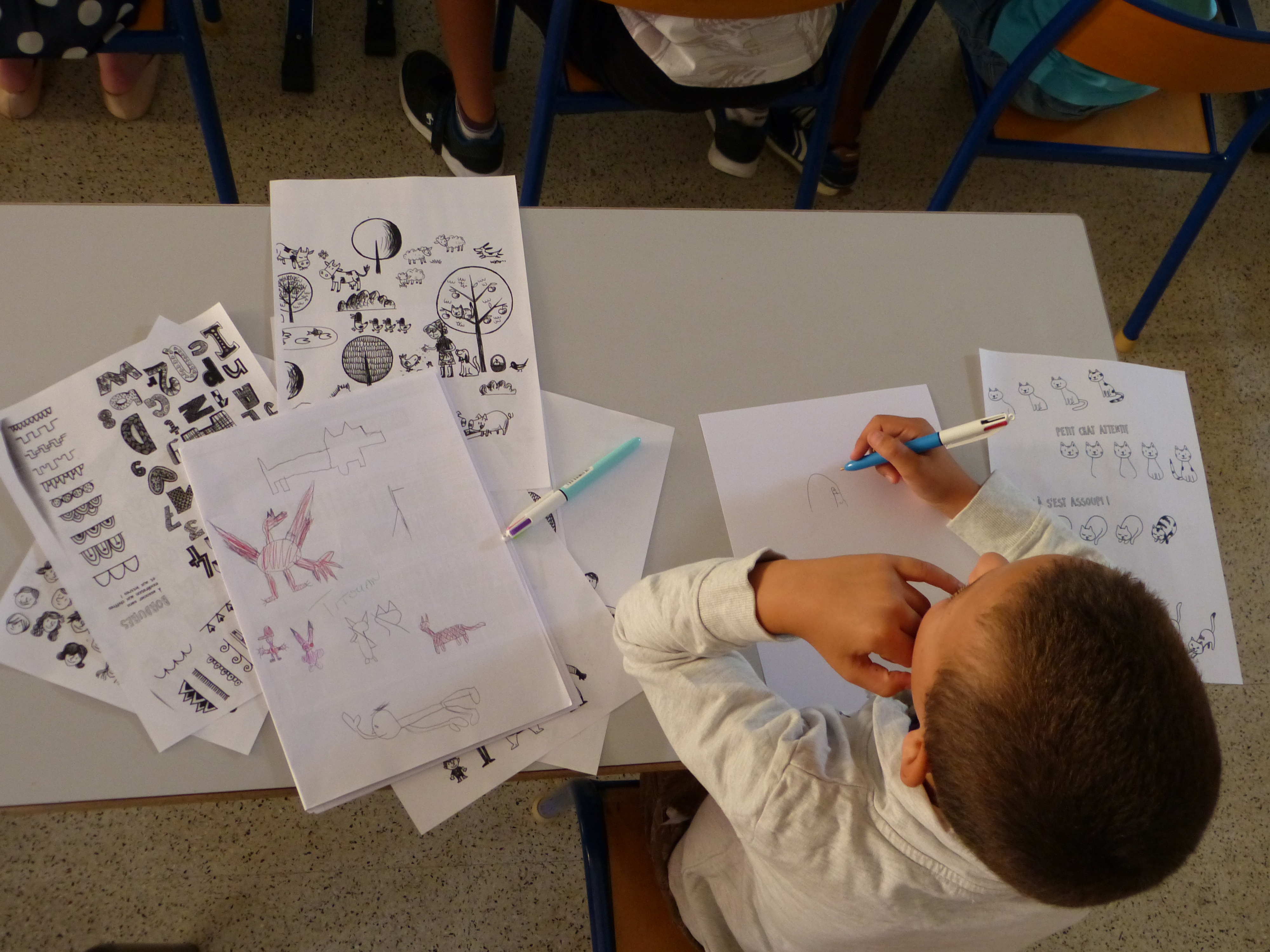 Un enfant assis à une table qui apprend à dessiner