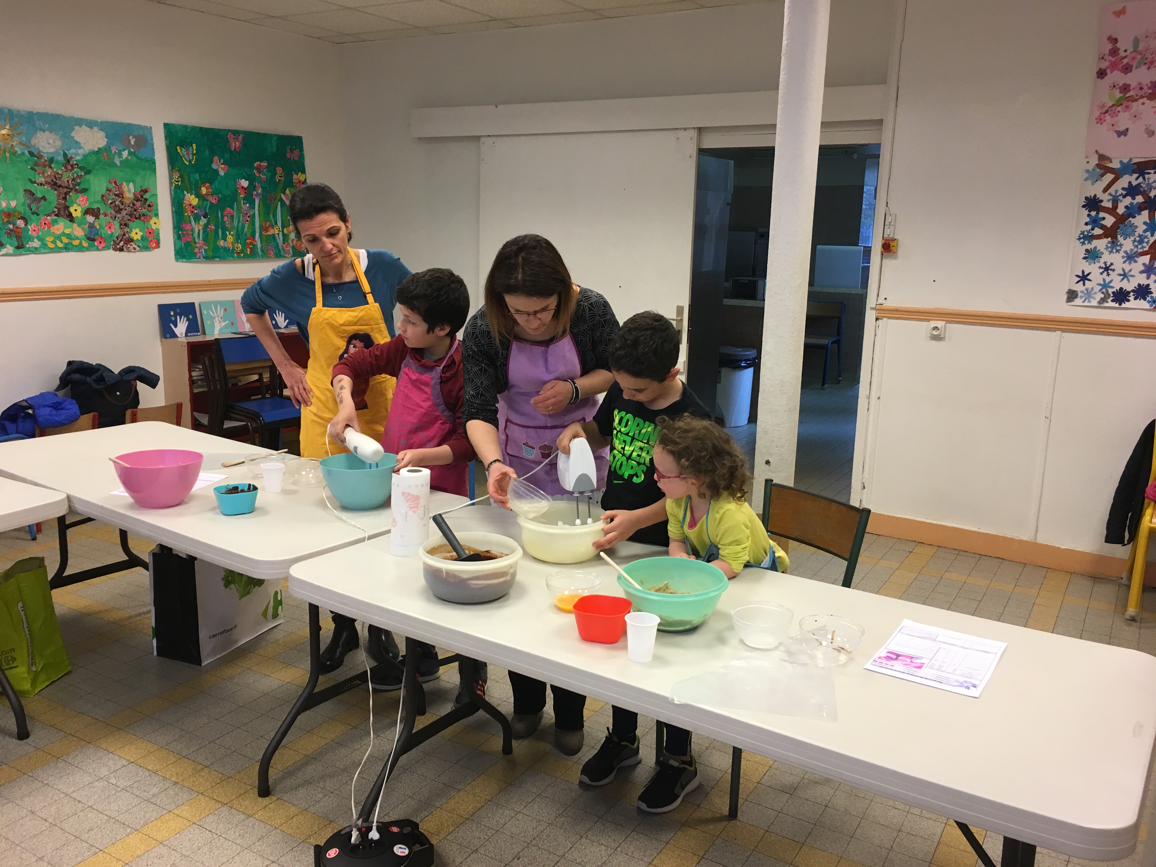 Groupe d&#039;enfants et de parents en pleine préparation de macarons