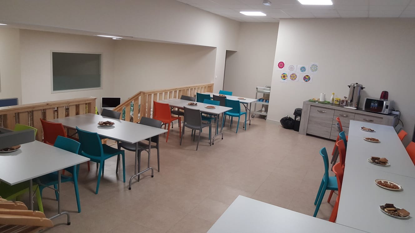 Salle d&#039;accueil : tables et chaises colorées dans une salle rénovée