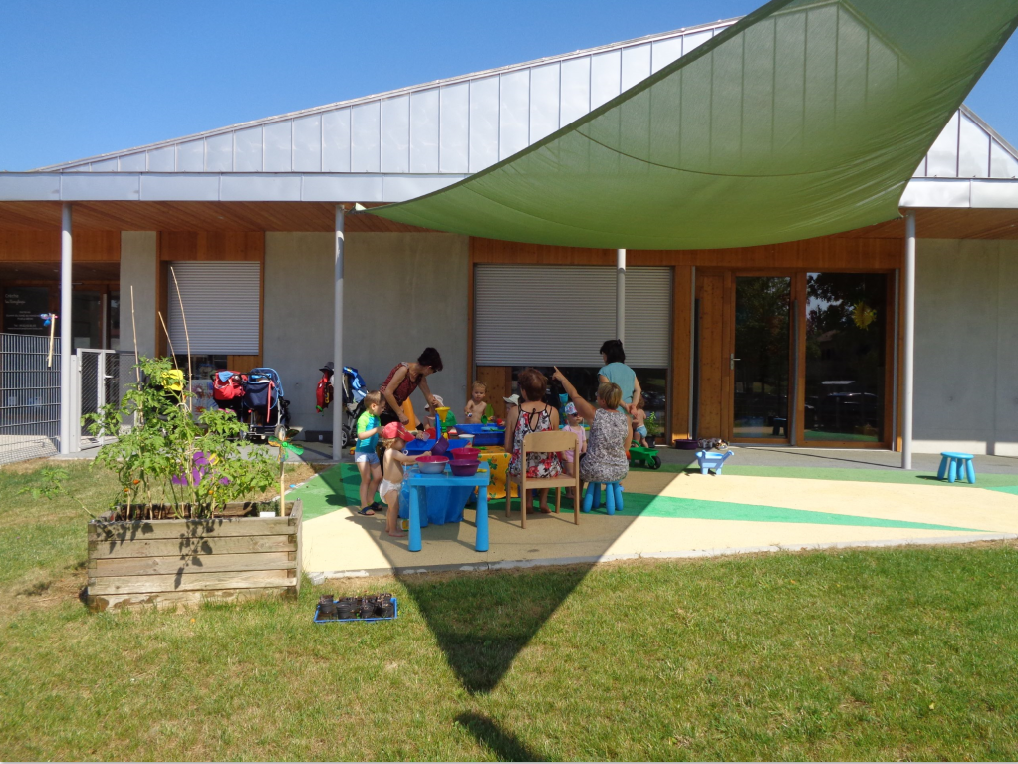 l&#039;équipe et les enfants profitent d&#039;une belle journée ensoleillée à l&#039;extérieur du relai à l&#039;ombre dans leur jardin privé