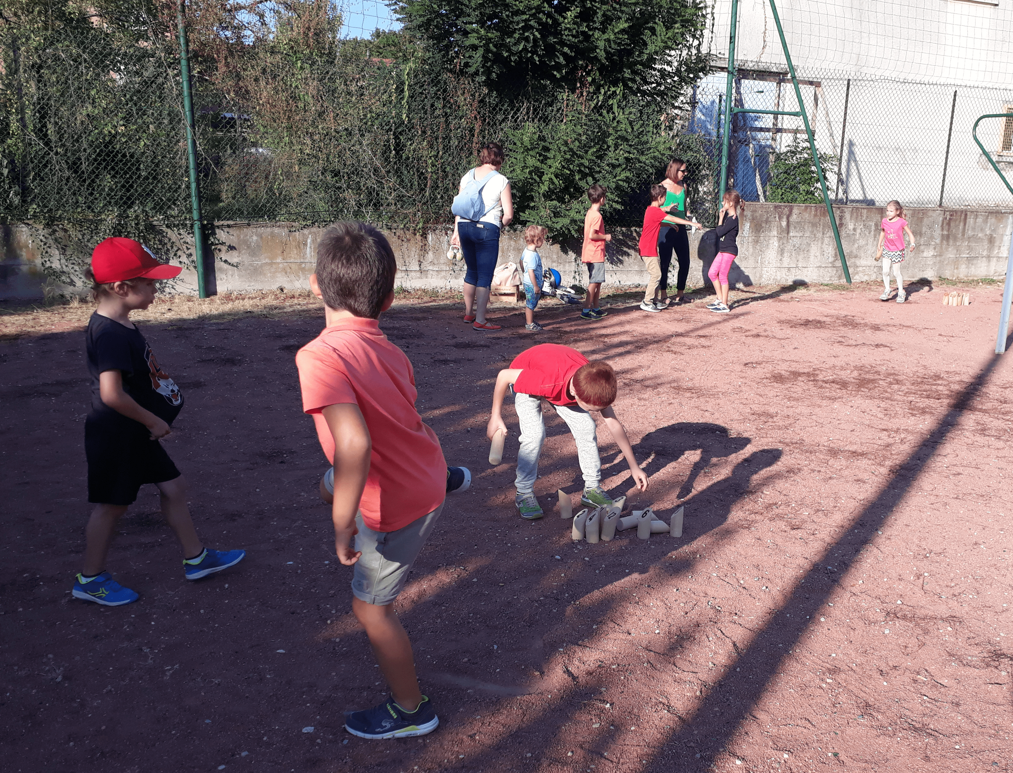 Des enfants jouent à la pétanque et au molki