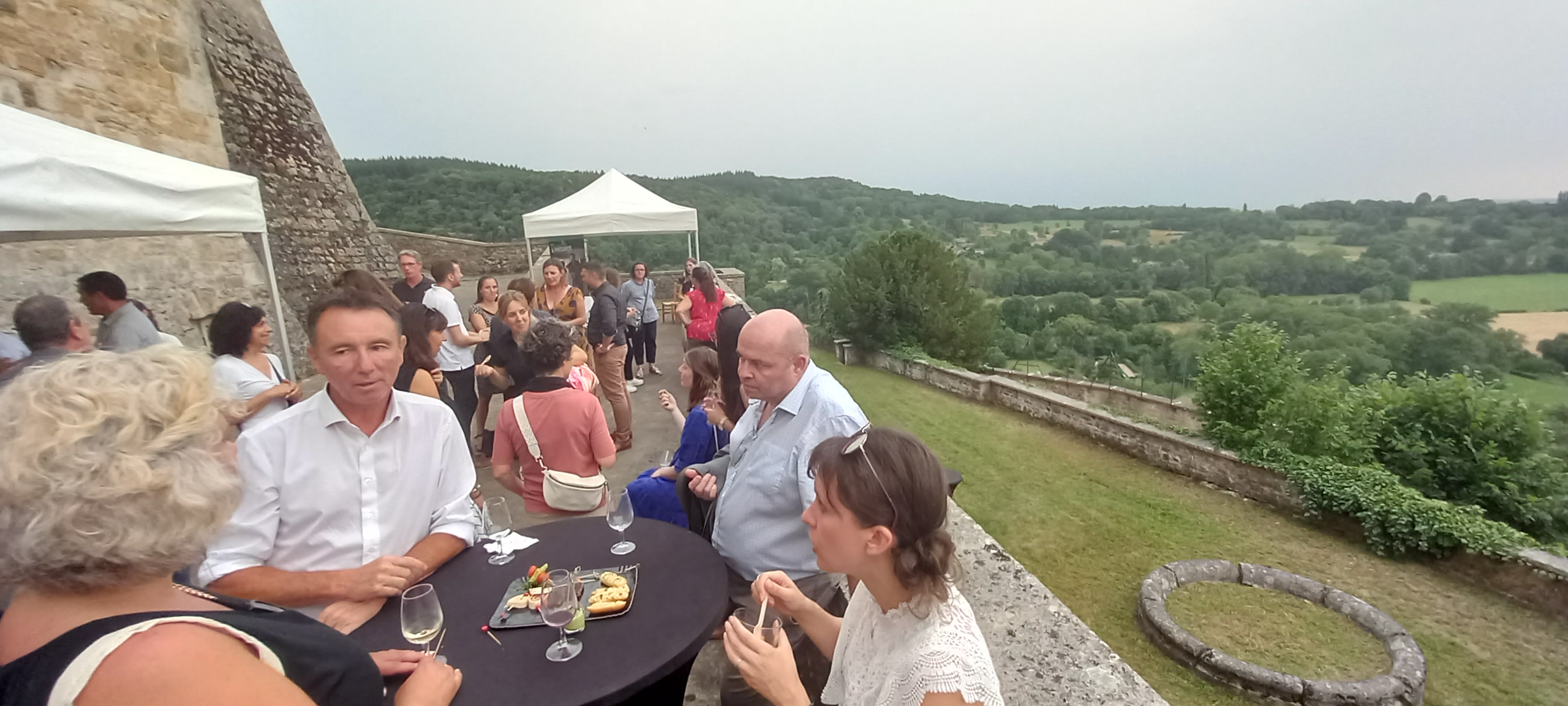 Devant le Château de Varey, des dizaines de personnes profitent du cocktail en pleine air devant la vue panoramique sur la plaine.
