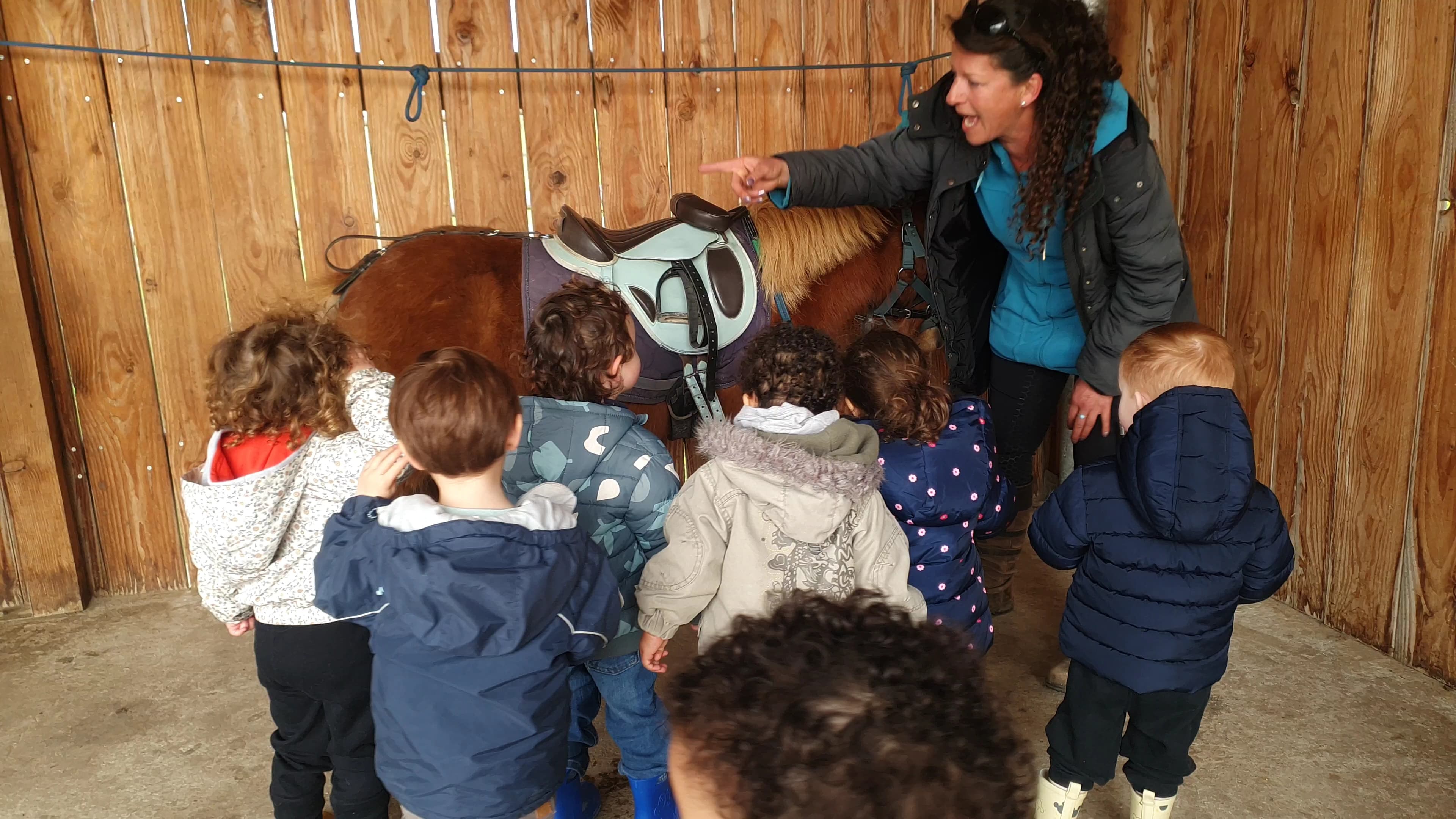 Enfants regroupés autour d&#039;un poney 