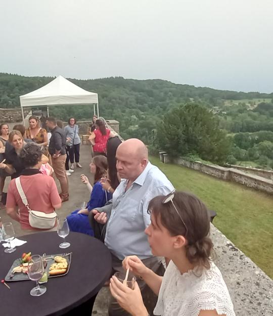 Devant le Château de Varey, des dizaines de personnes profitent du cocktail en pleine air devant la vue panoramique sur la plaine.