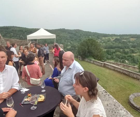 Devant le Château de Varey, des dizaines de personnes profitent du cocktail en pleine air devant la vue panoramique sur la plaine.
