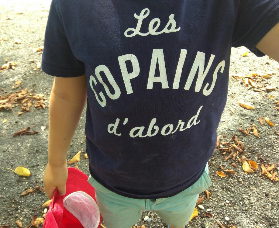 Enfant portant un tee-shirt "Les copains d'abord"