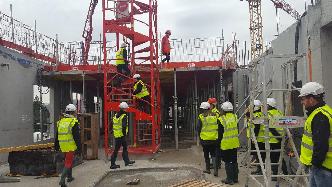 chantier de l’hôpital de Belley : on voit des hommes et femmes en gilet jaune et casques, équipés en tout sécurité, visitant le chantier