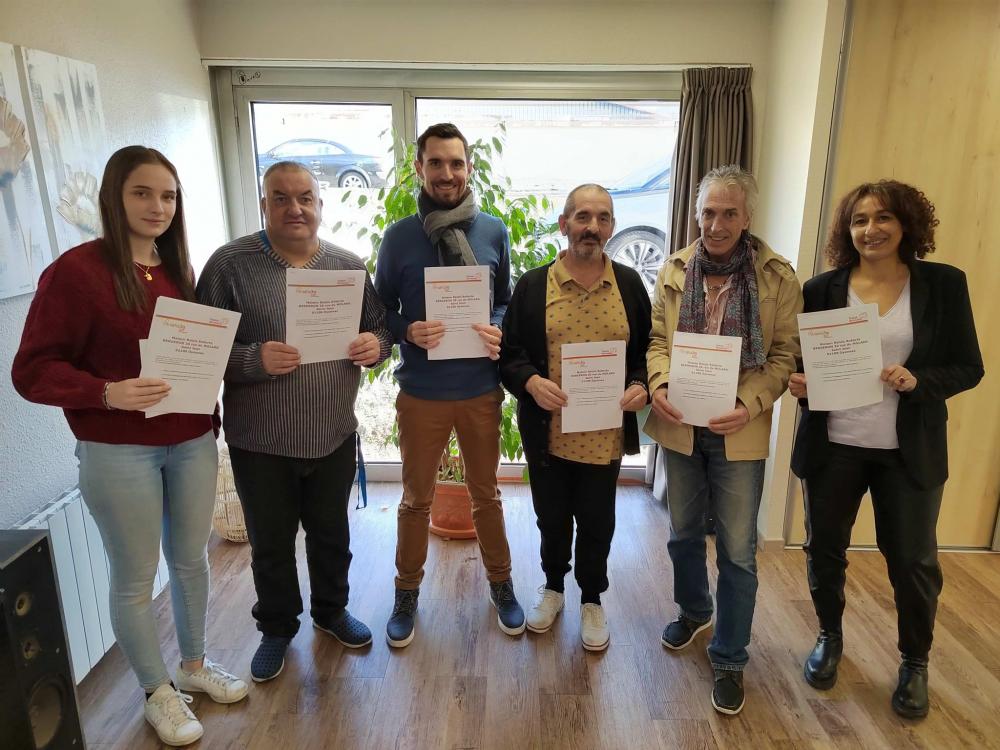 Jour de la signature : 3 bénévoles entourés de 3 salariés des pensions de famille, posent avec fierté pour la photo avec leurs contrat dans la main